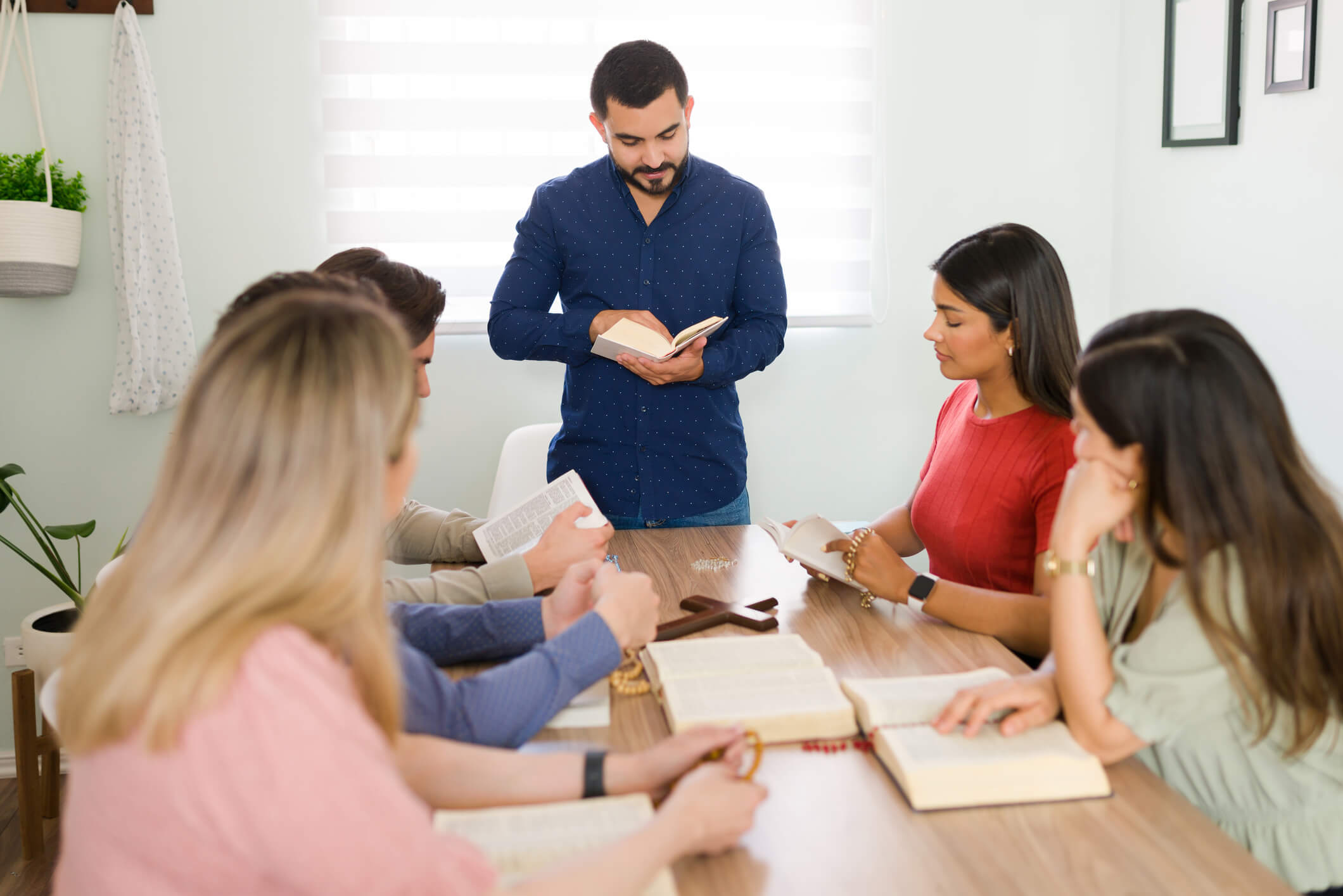 Group reading at a table, man standing.